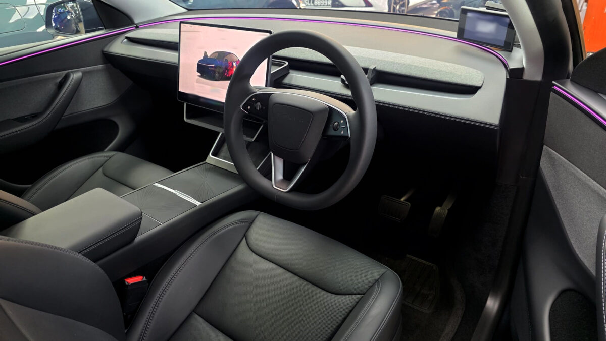 Reflections across the coated panels of the Tesla Model Y.