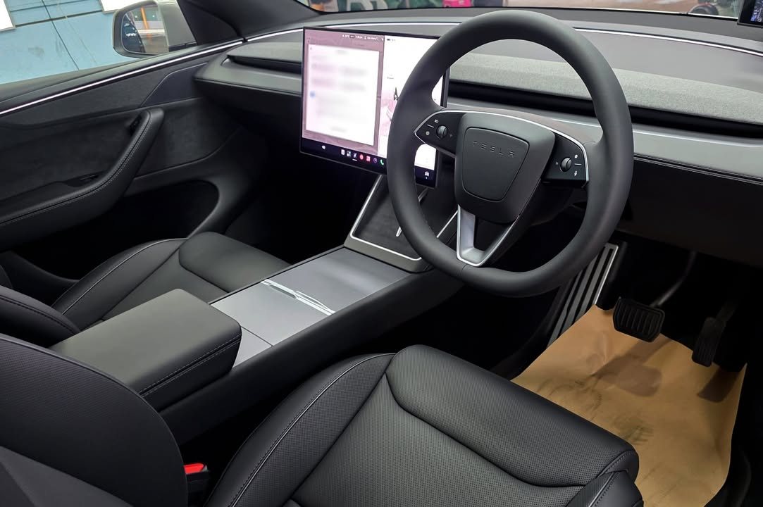 Interior with black seats, steering wheel and centre screen.