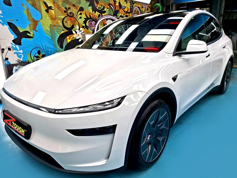White Tesla Model Y L from the front three-quarter, its bonnet glossy after the ZeTough Titanium coating.