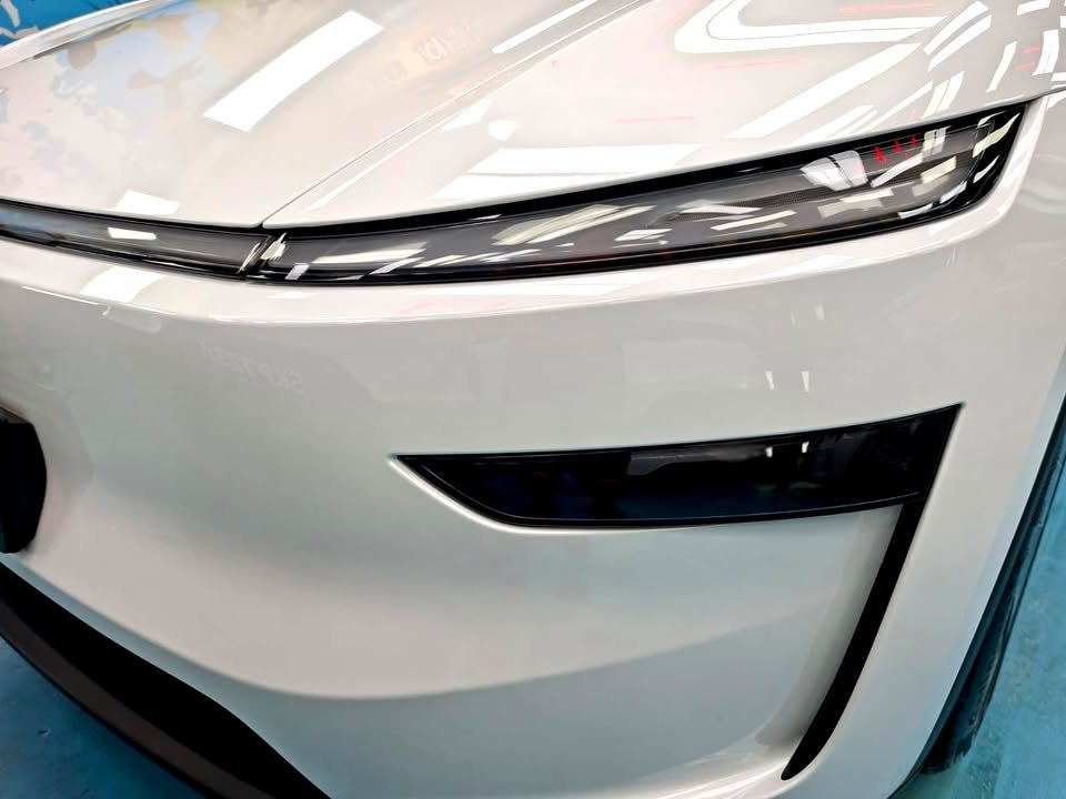 Close-up of the Model Y L's front bumper and light bar in white paint.