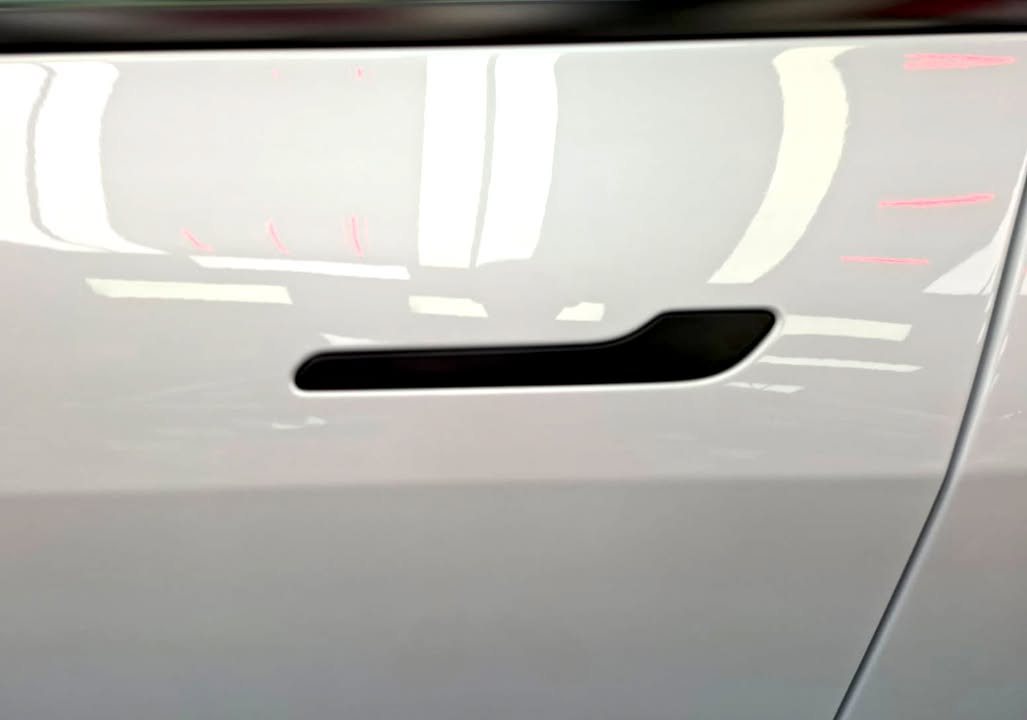 Flush door handle on the white door panel of the Model Y L.