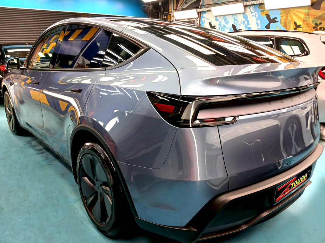 Rear quarter of the Tesla Model Y, glossy and protected.