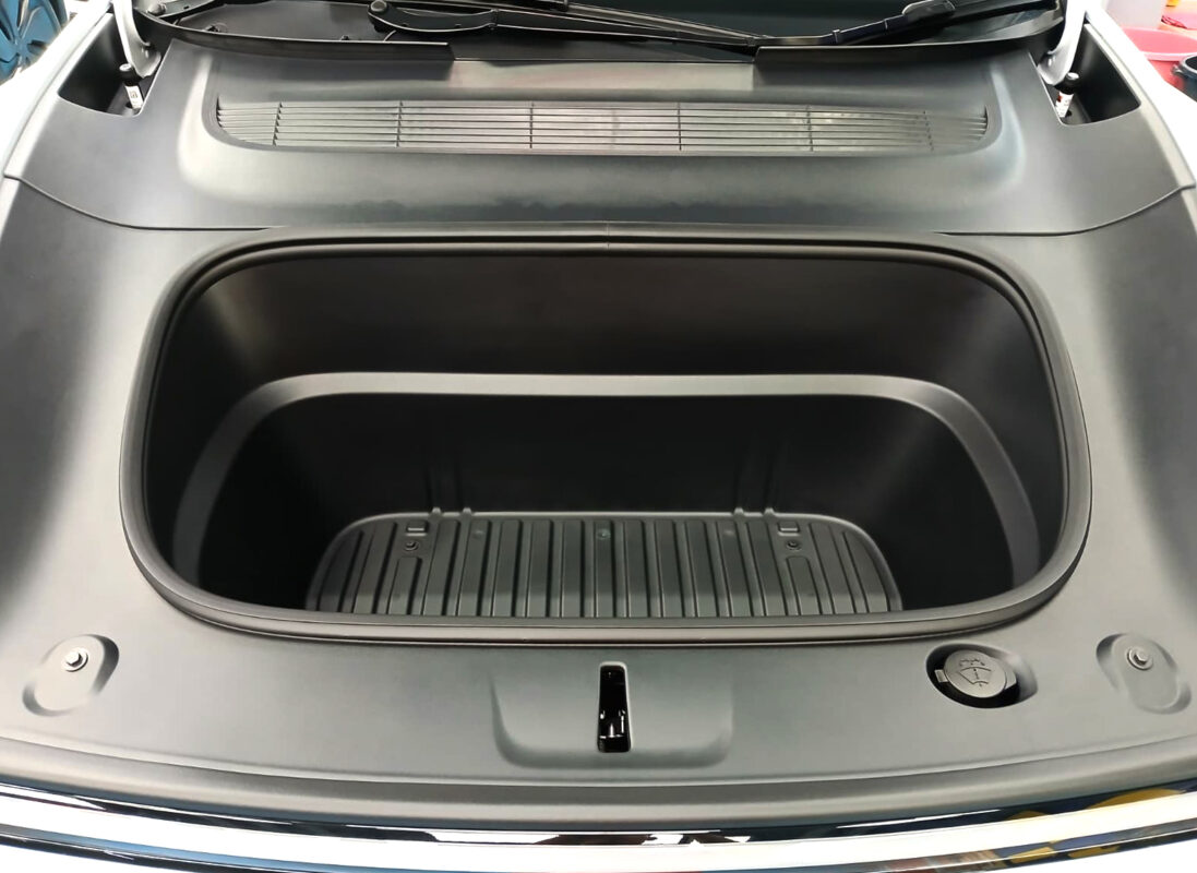 Reflections across the coated panels of the Tesla Model Y.