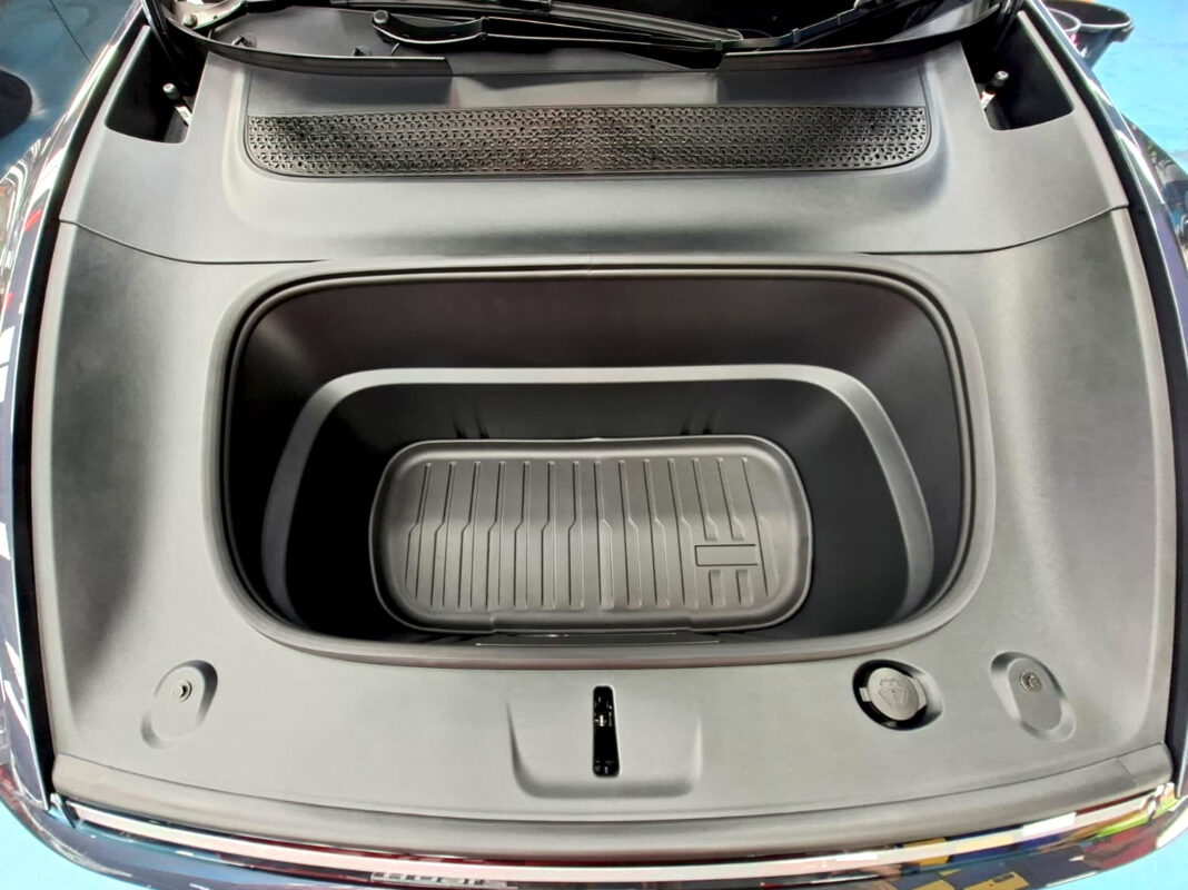 Reflections across the coated panels of the Tesla Model Y.