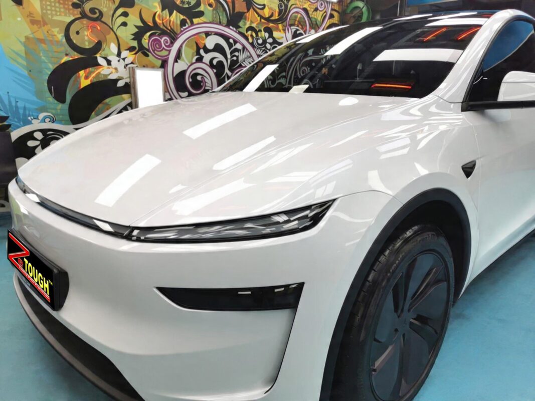 The Tesla Model Y's coated paintwork under workshop lighting.