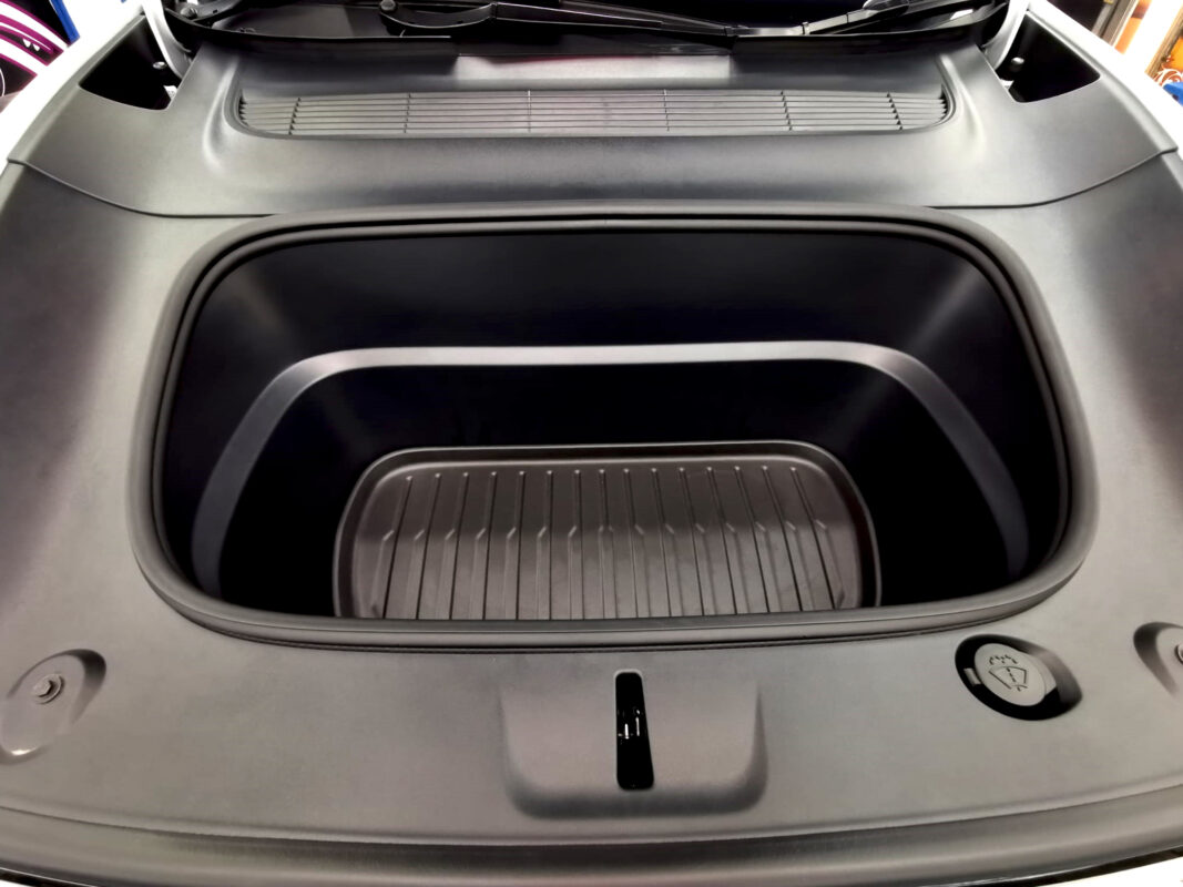 Reflections across the coated panels of the Tesla Model Y.