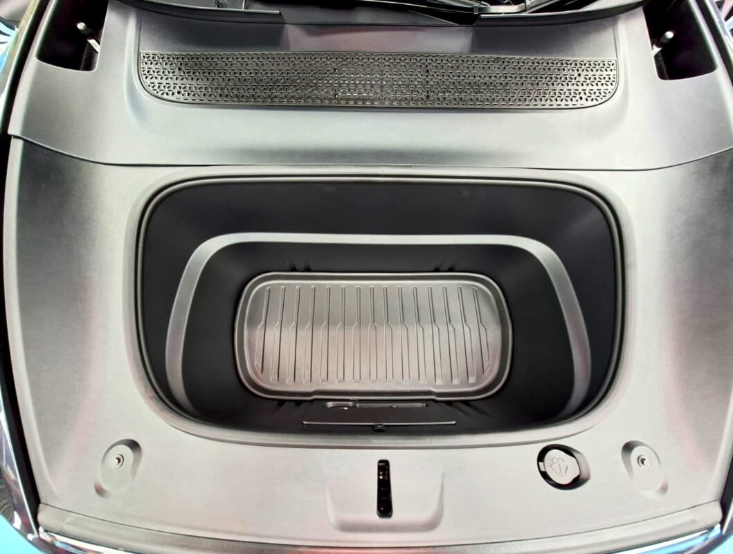 Reflections across the coated panels of the Tesla Model Y.