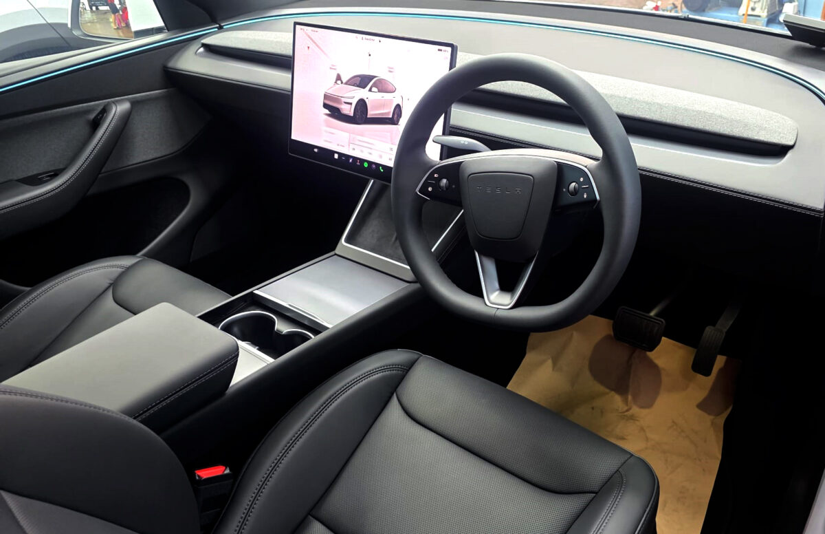 Reflections across the coated panels of the Tesla Model Y.