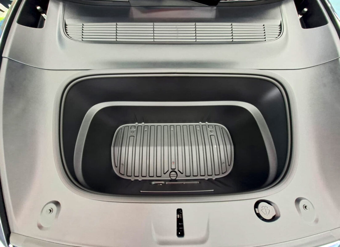 Reflections across the coated panels of the Tesla Model Y.