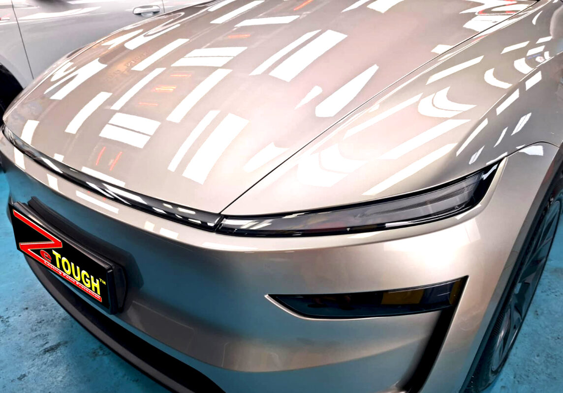 The Tesla Model YL's coated paintwork under workshop lighting.