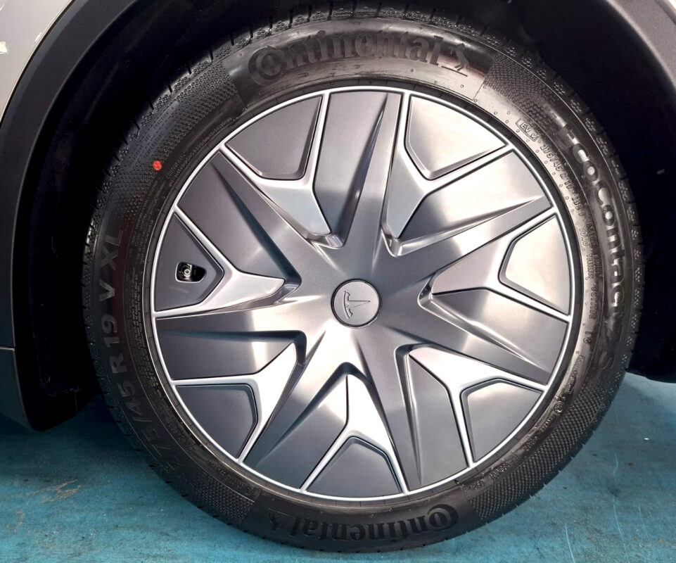 Detail of the Tesla Model YL's aero wheel and Continental tyre.