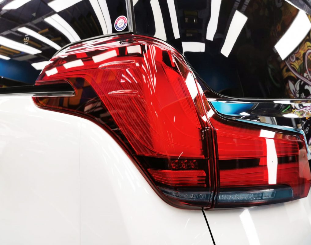 The coated bonnet of the Toyota Alphard under workshop lighting.