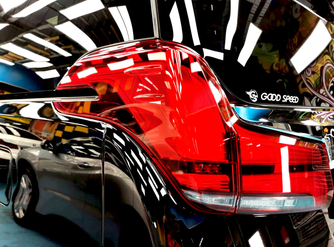 The coated bonnet of the Toyota Alphard under workshop lighting.