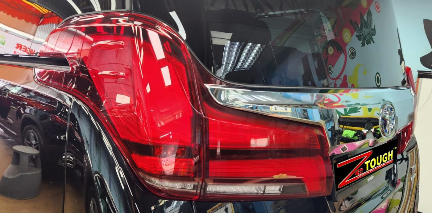 The coated bonnet of the Toyota Alphard under workshop lighting.