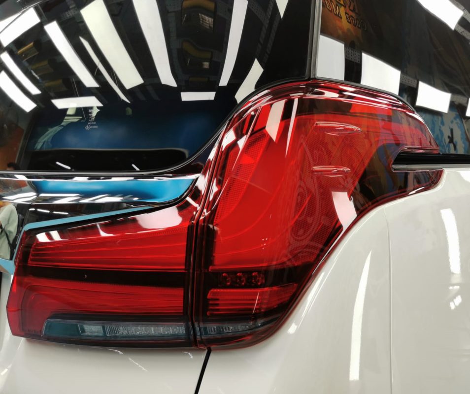 The coated bonnet of the Toyota Alphard under workshop lighting.