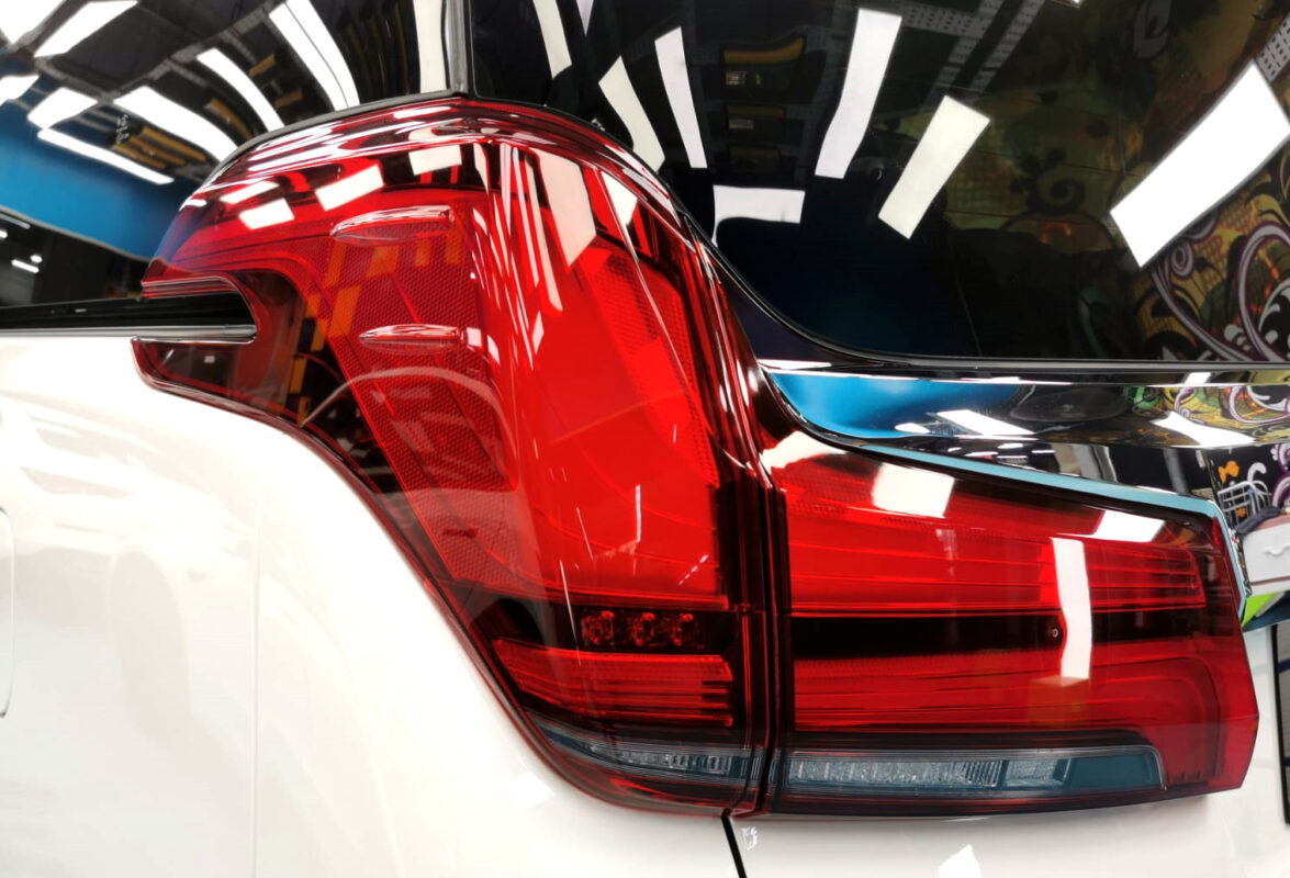 The coated bonnet of the Toyota Alphard under workshop lighting.
