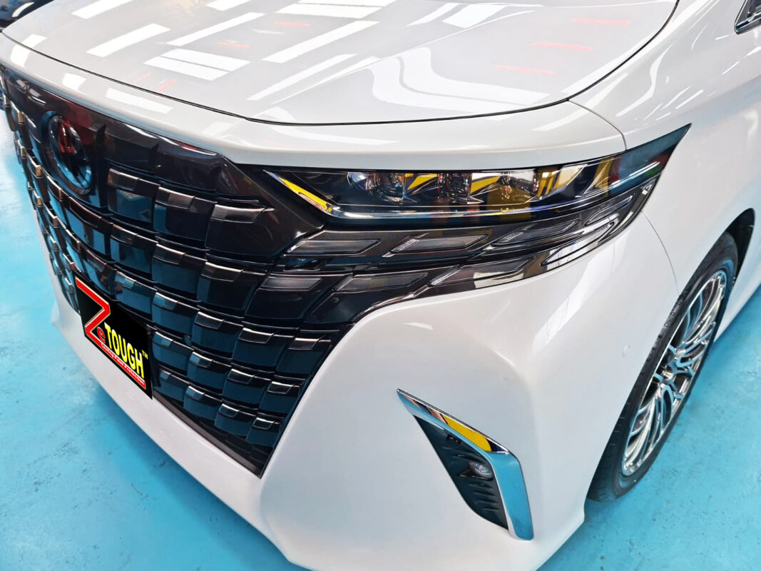 The Toyota Alphard's coated paintwork under workshop lighting.