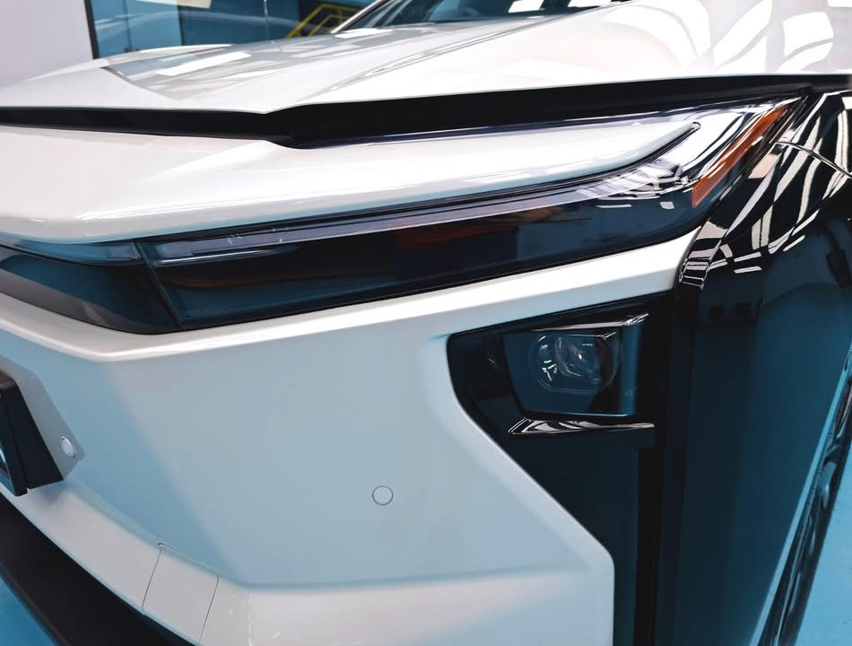 Close view of the bZ4X headlight and white front corner.