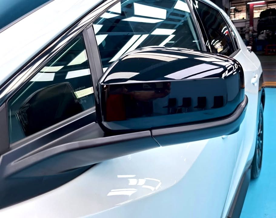 Gloss black wing mirror on the white Toyota bZ4X.