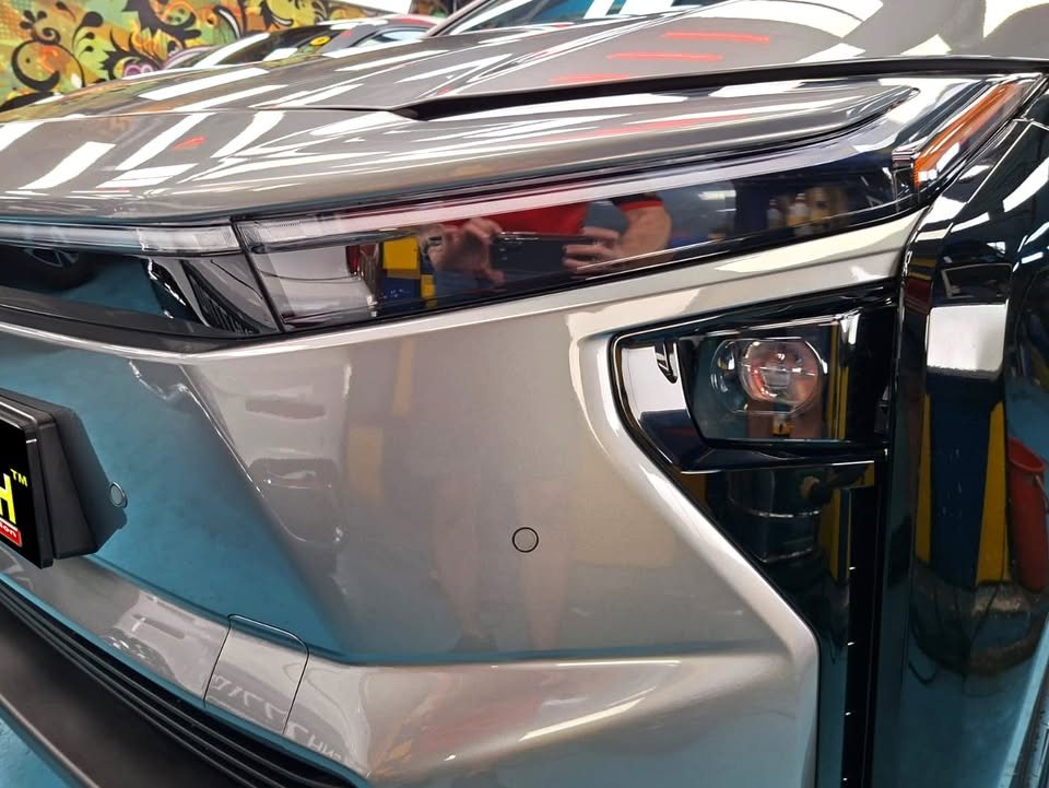 Close view of the bZ4X headlight and grey front corner panel.