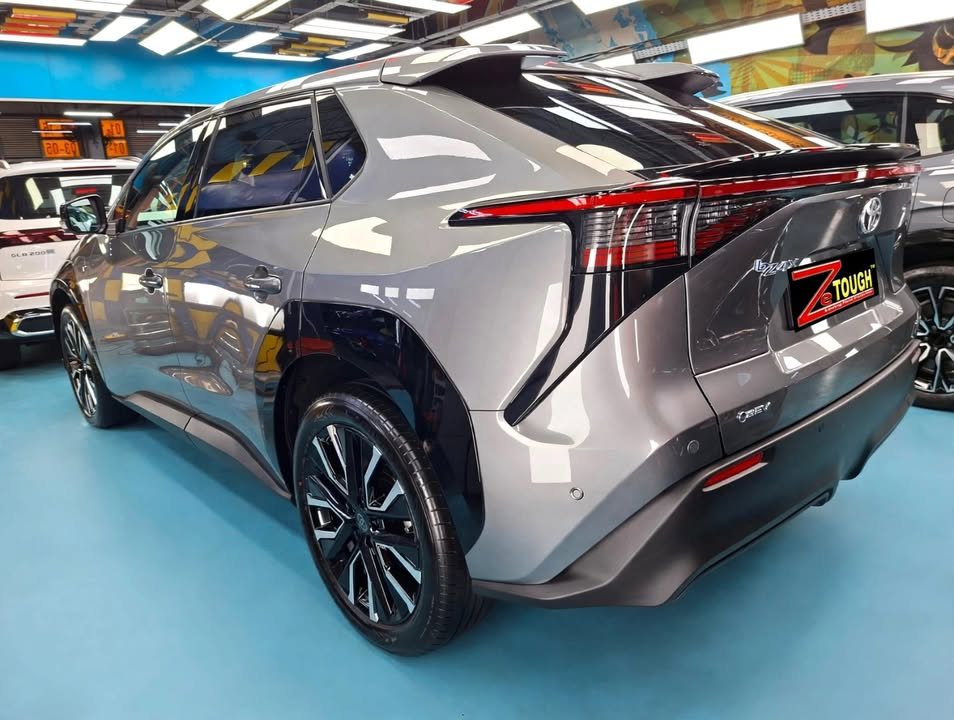 Rear three-quarter view of the grey Toyota bZ4X with a ZeTough plate.
