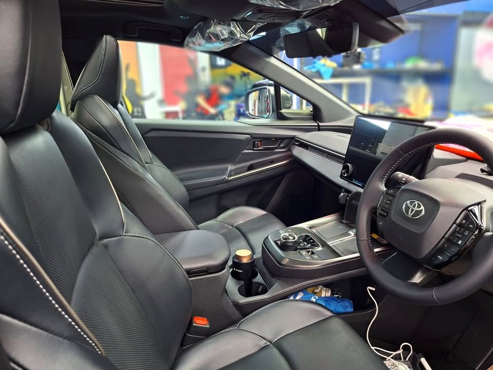 Front cabin of the Toyota bZ4X with black leather seats and the centre screen.