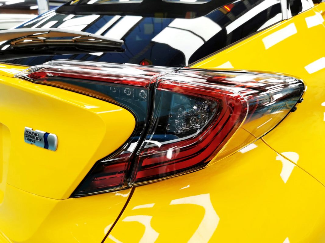 The coated bonnet of the Toyota C-HR Hybrid under workshop lighting.