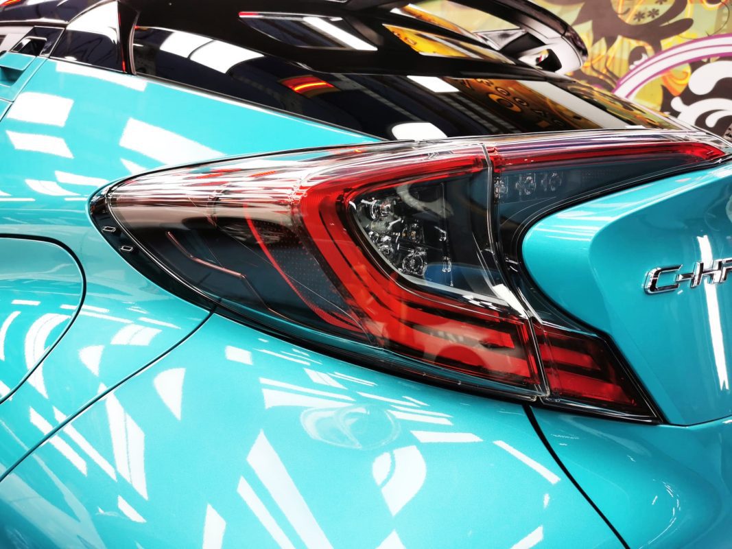 The coated bonnet of the Toyota C-HR under workshop lighting.