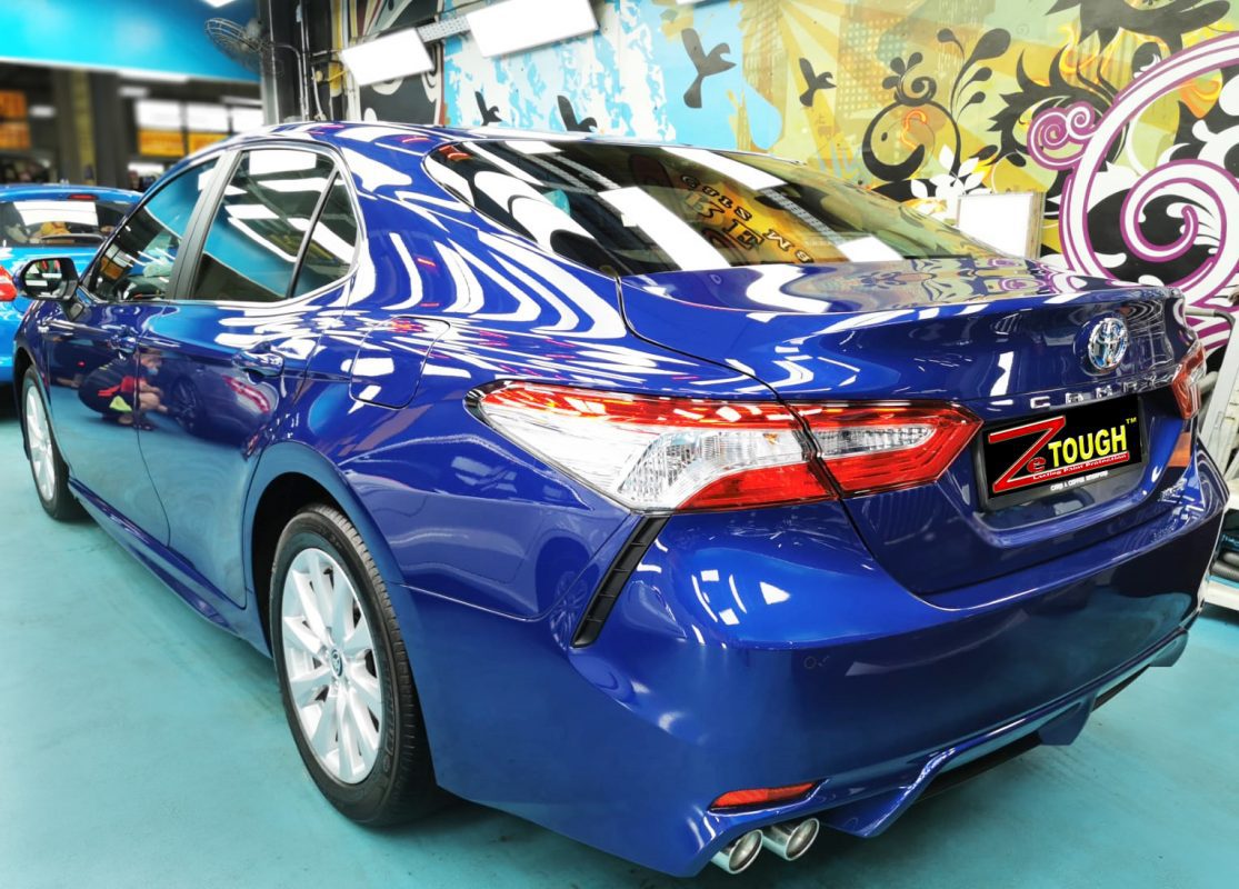 Rear quarter of the Toyota Camry Hybrid, glossy and protected.