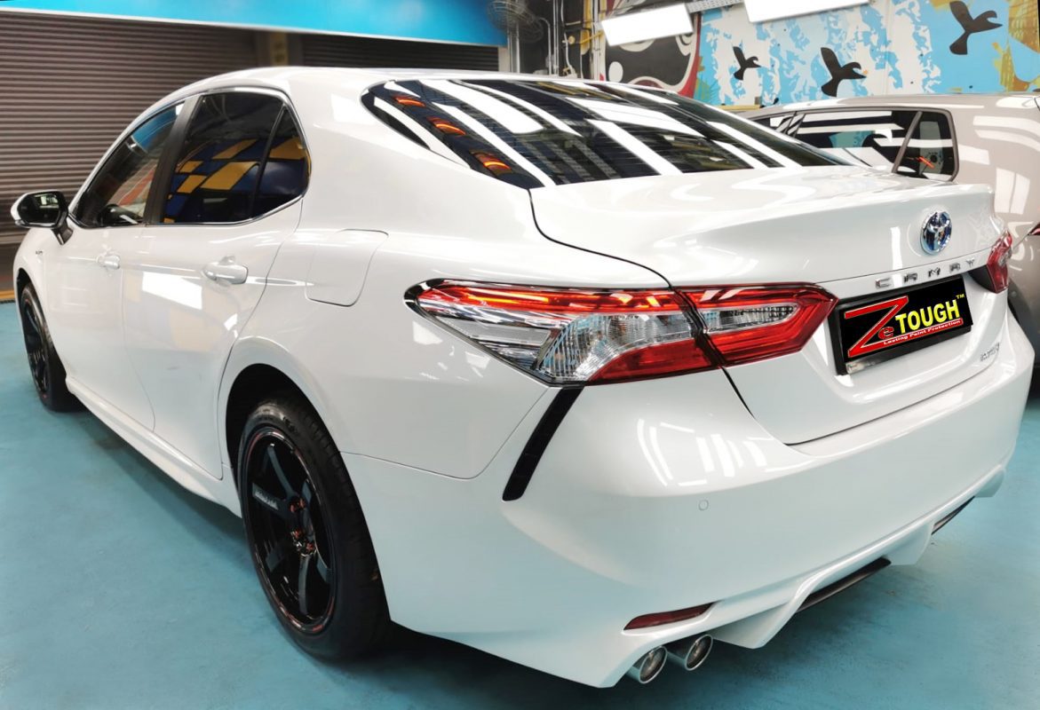 Rear quarter of the Toyota Camry Hybrid, glossy and protected.