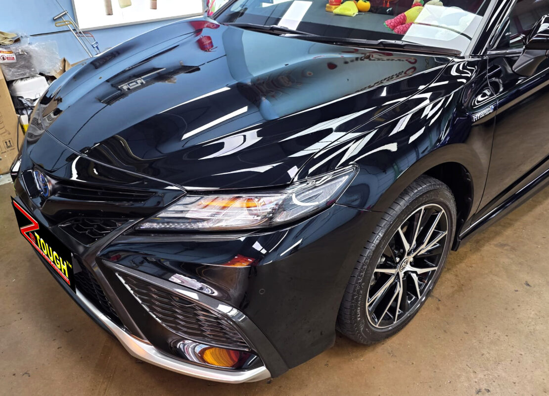 The Toyota Camry's coated paintwork under workshop lighting.