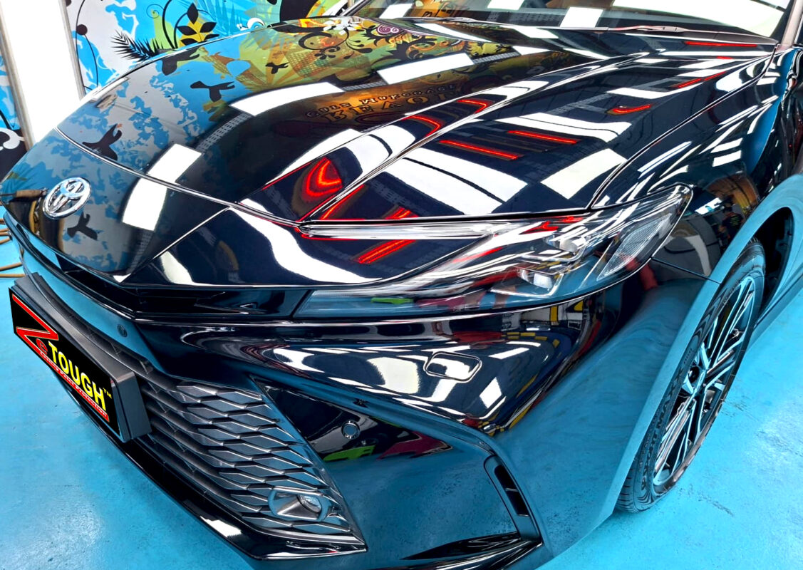 The Toyota Camry's coated paintwork under workshop lighting.