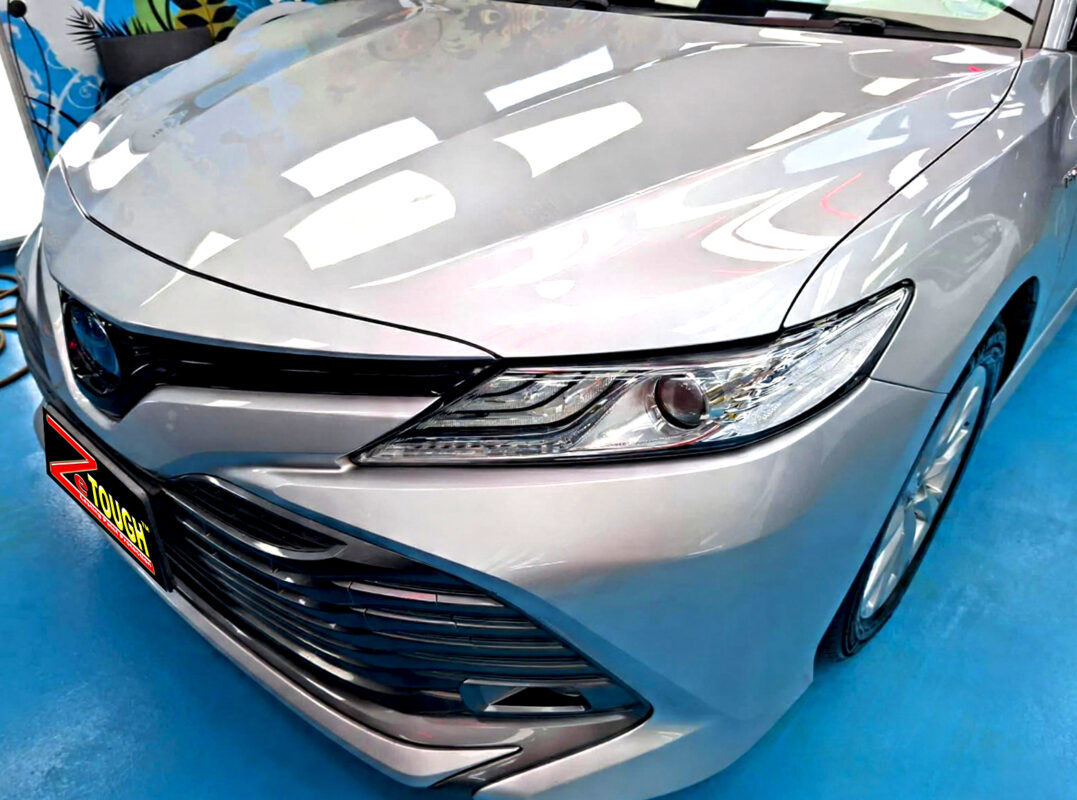 The Toyota Camry's coated paintwork under workshop lighting.
