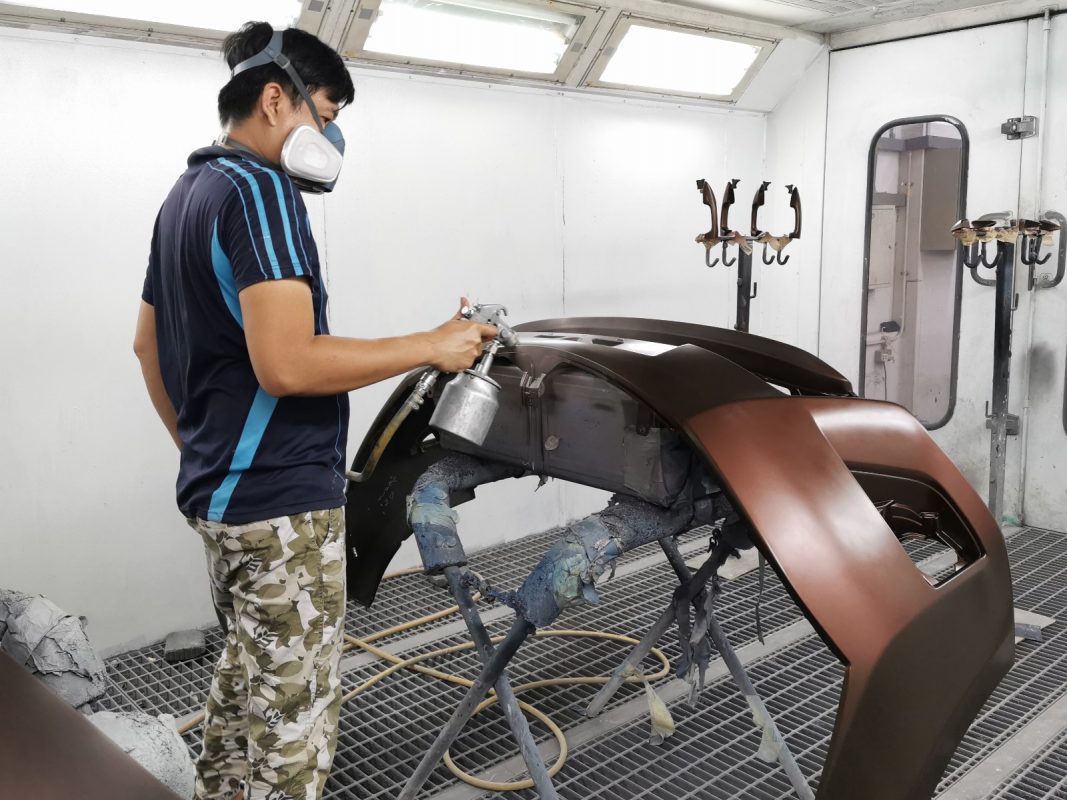 The Corolla Altis being touched up after spraying for an even surface.
