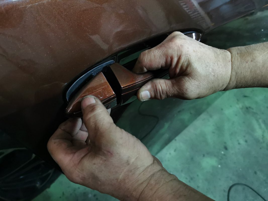 Previously removed car parts being refitted onto the Corolla Altis.