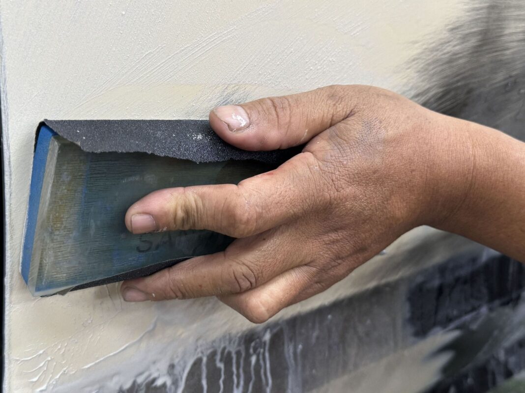 Body filler levelling a panel on the Corolla Altis before paint.