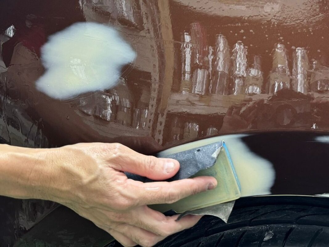 Hand-sanding the body filler smooth on the Corolla Altis.