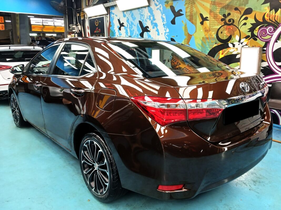 A Revol Carz painter laying the new coat onto the Corolla Altis in the spray booth.
