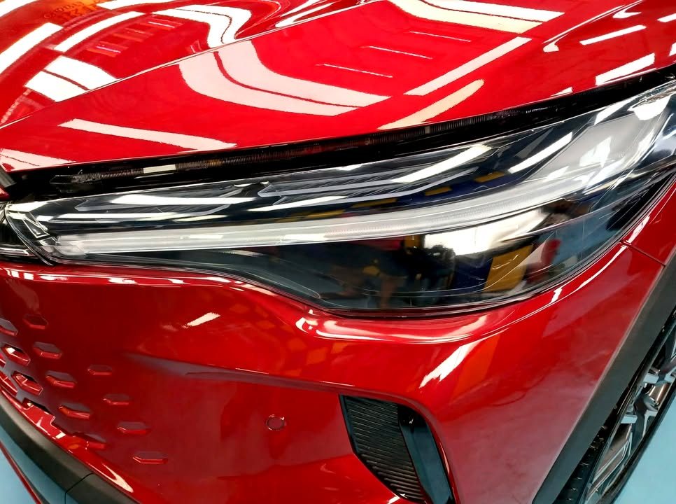 Close view of the headlight and red front bumper.