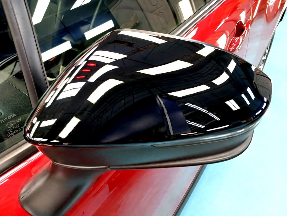 Gloss black wing mirror cap on the red Toyota.