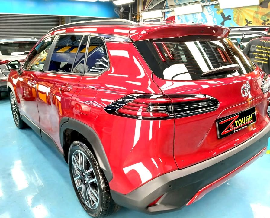 Rear three-quarter view of the red Toyota Corolla Cross with a ZeTough plate.
