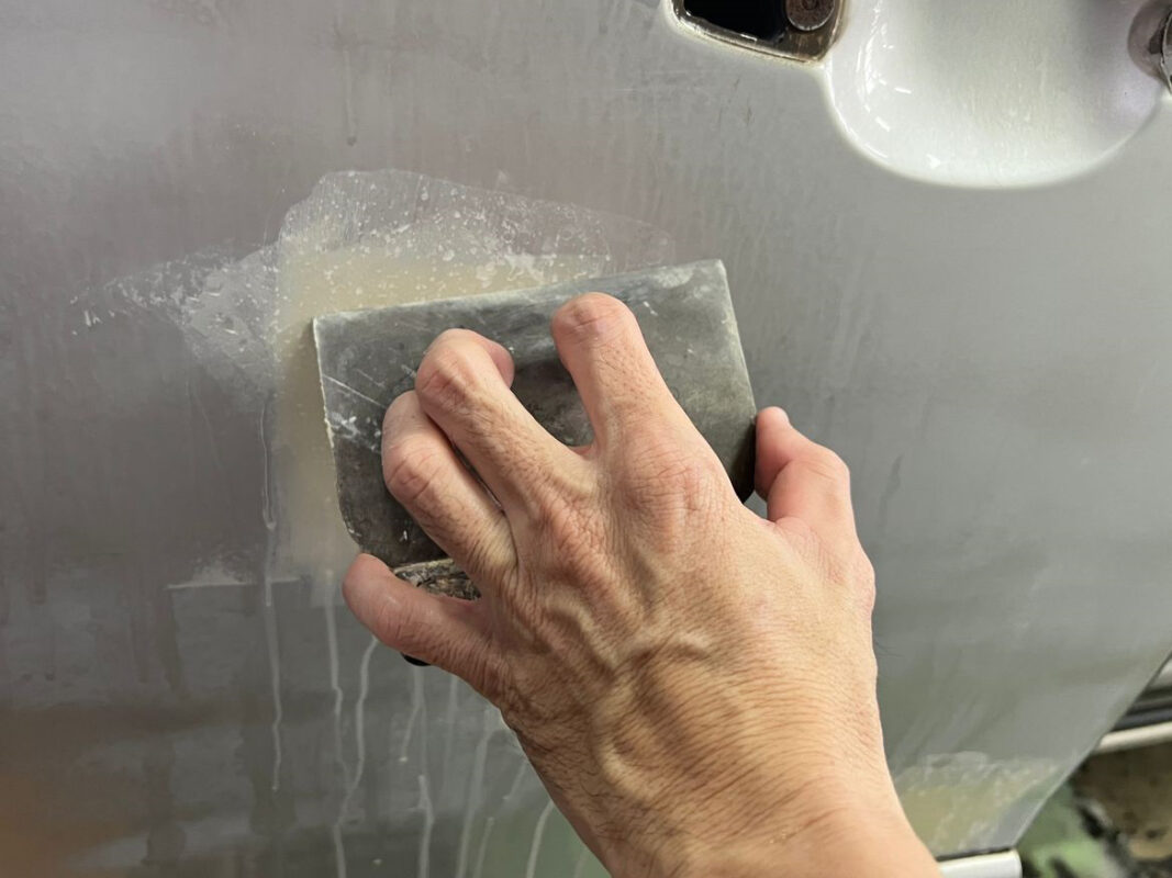 Sanding a panel on the Estima, levelling the surface before priming.