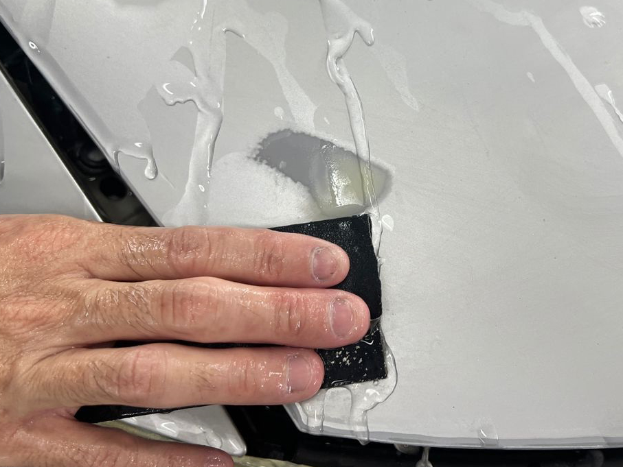 Panel prep close-up showing the surface being checked for any remaining imperfections.