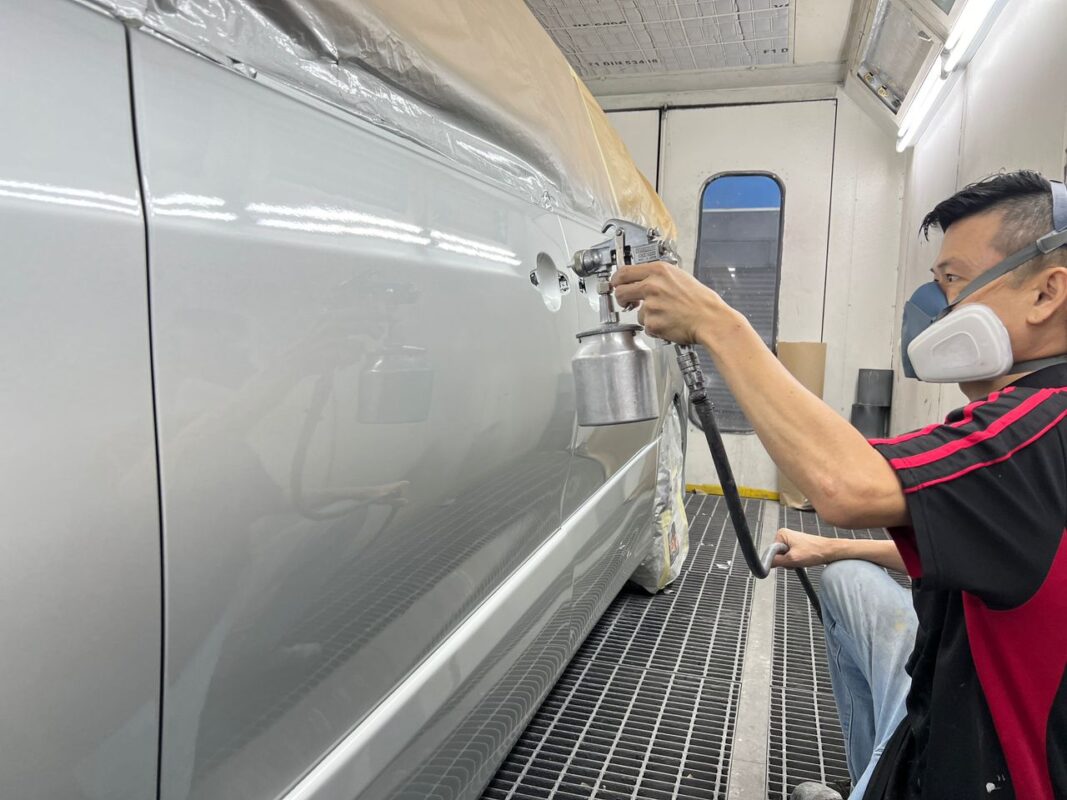 The Estima in the spray booth, fresh paint being laid on the exterior.