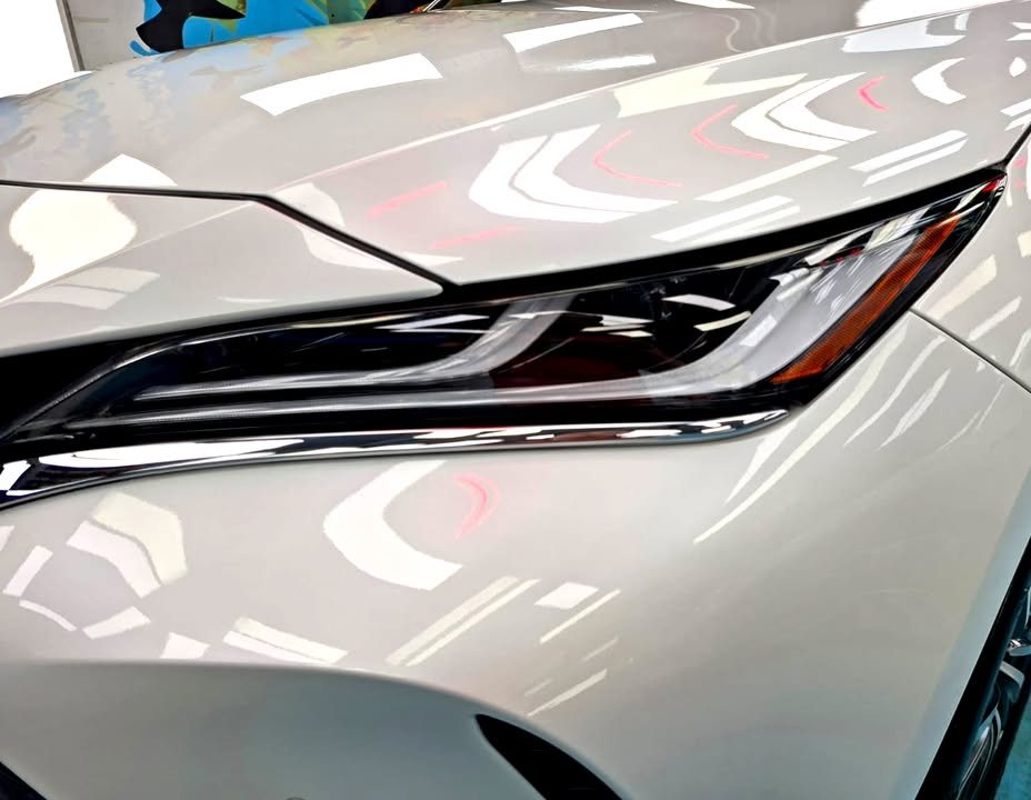 Close-up of the Harrier headlight with reflections in the white paint.
