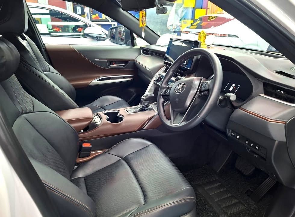Black leather seats and dashboard with brown trim inside the Harrier.