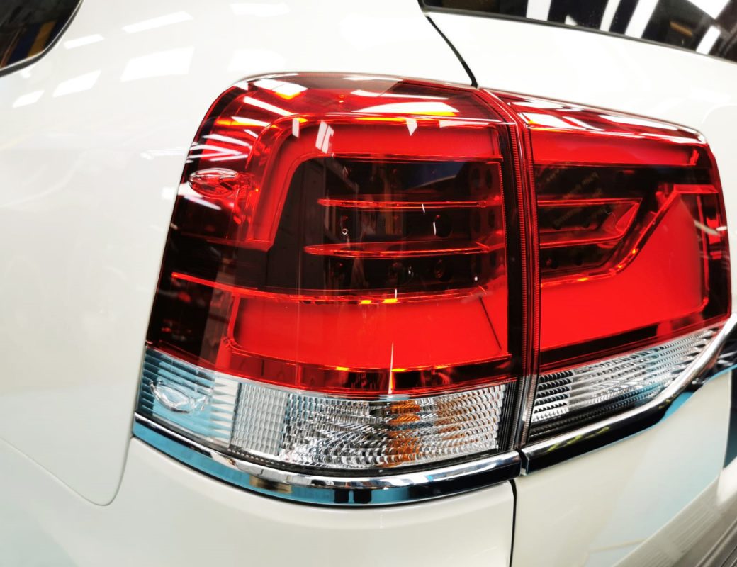 The coated bonnet of the Toyota Land Cruiser under workshop lighting.