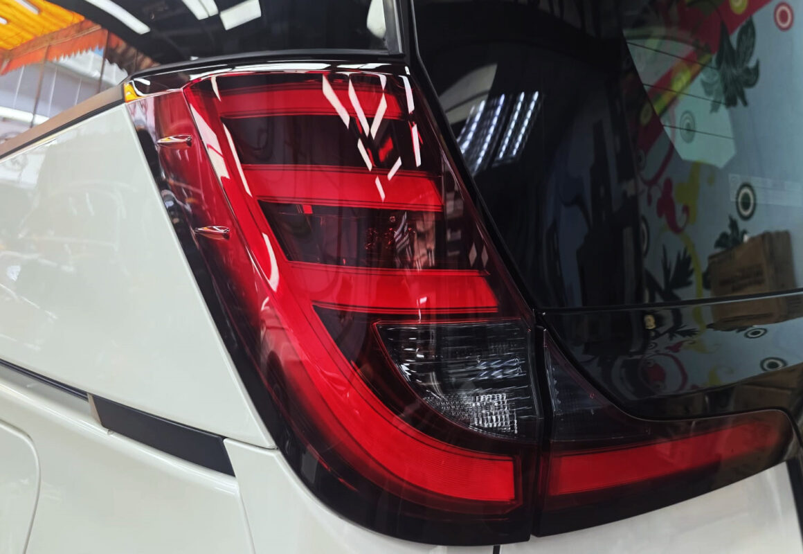 The coated bonnet of the Toyota Noah under workshop lighting.