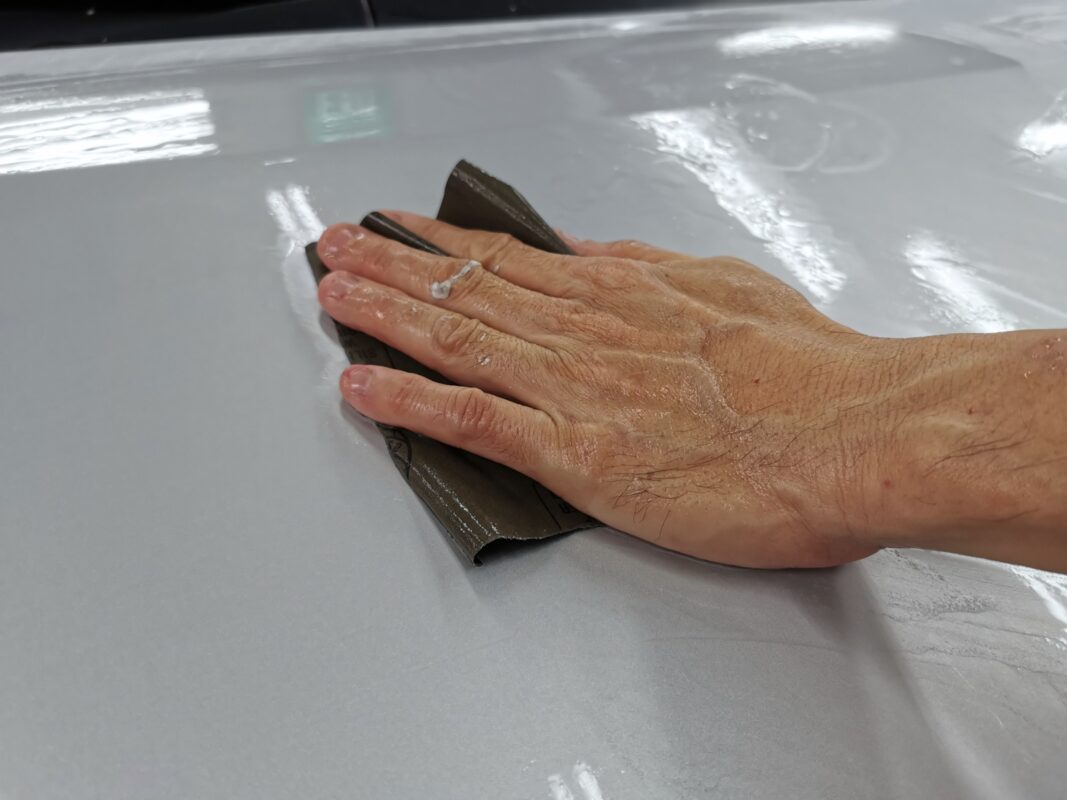 A panel on the Toyota Noah being wet-sanded flat before priming.