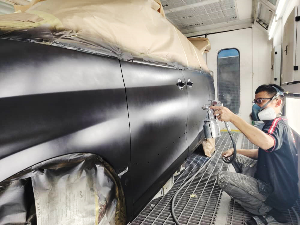 Inside the spray booth, the Toyota Previa Aeras receiving its new coat of paint.
